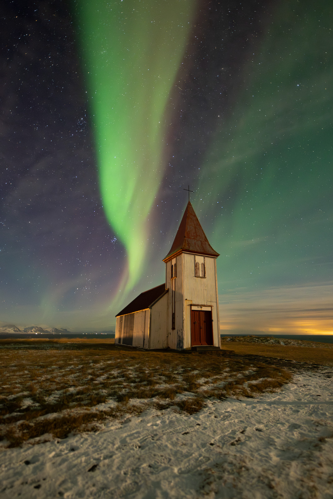 Auroras above a church in Iceland in snaefellsnes peninsula