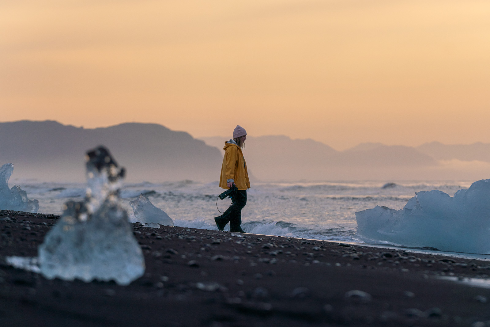 Femme marchant dans un paysage islandais en fin d'été avec lumière dorée rasante, moins de touristes en septembre