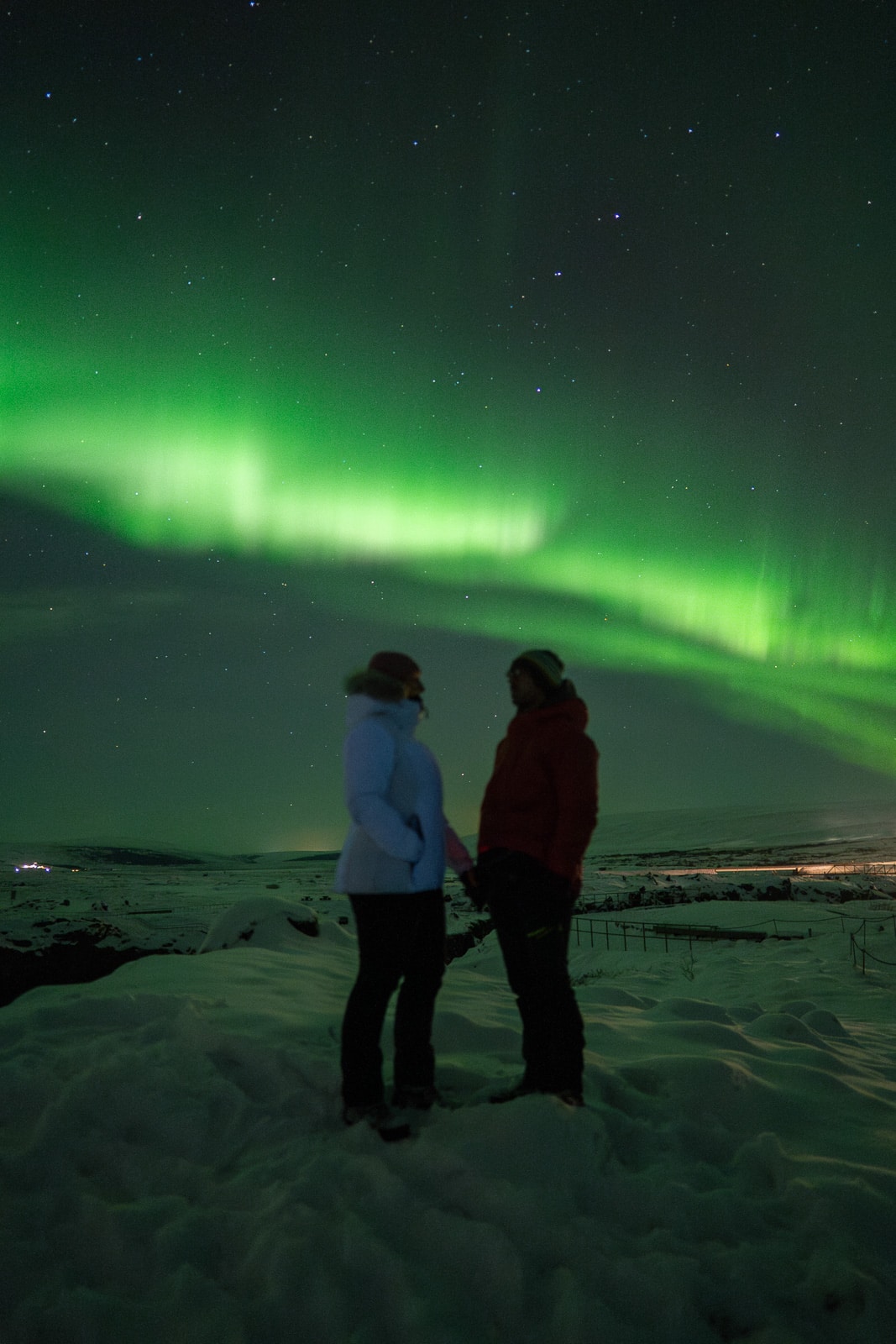 Couple sous les aurores boréales en Islande, profitant du spectacle naturel