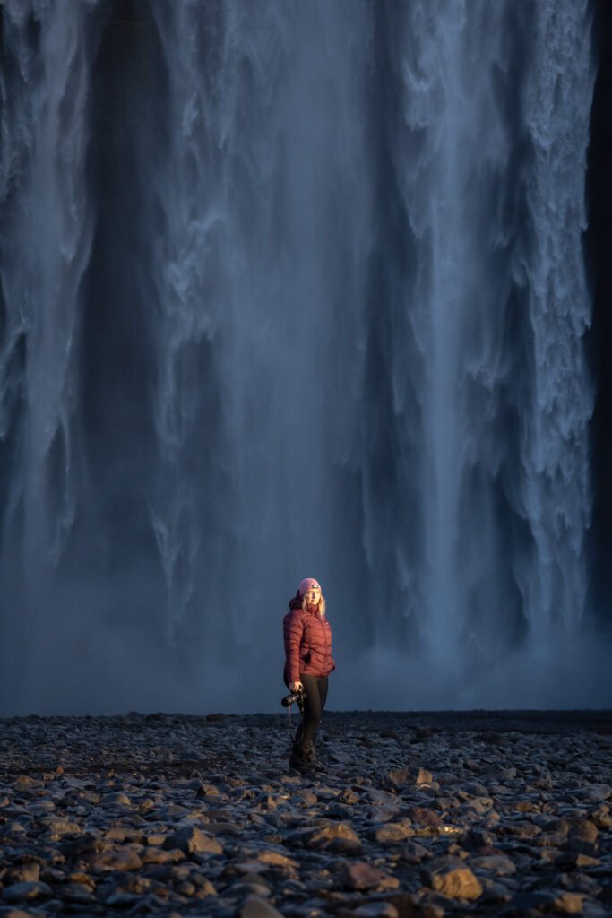 Femme équipée d'une doudoune chaude devant Skogafoss, une cascade islandaise