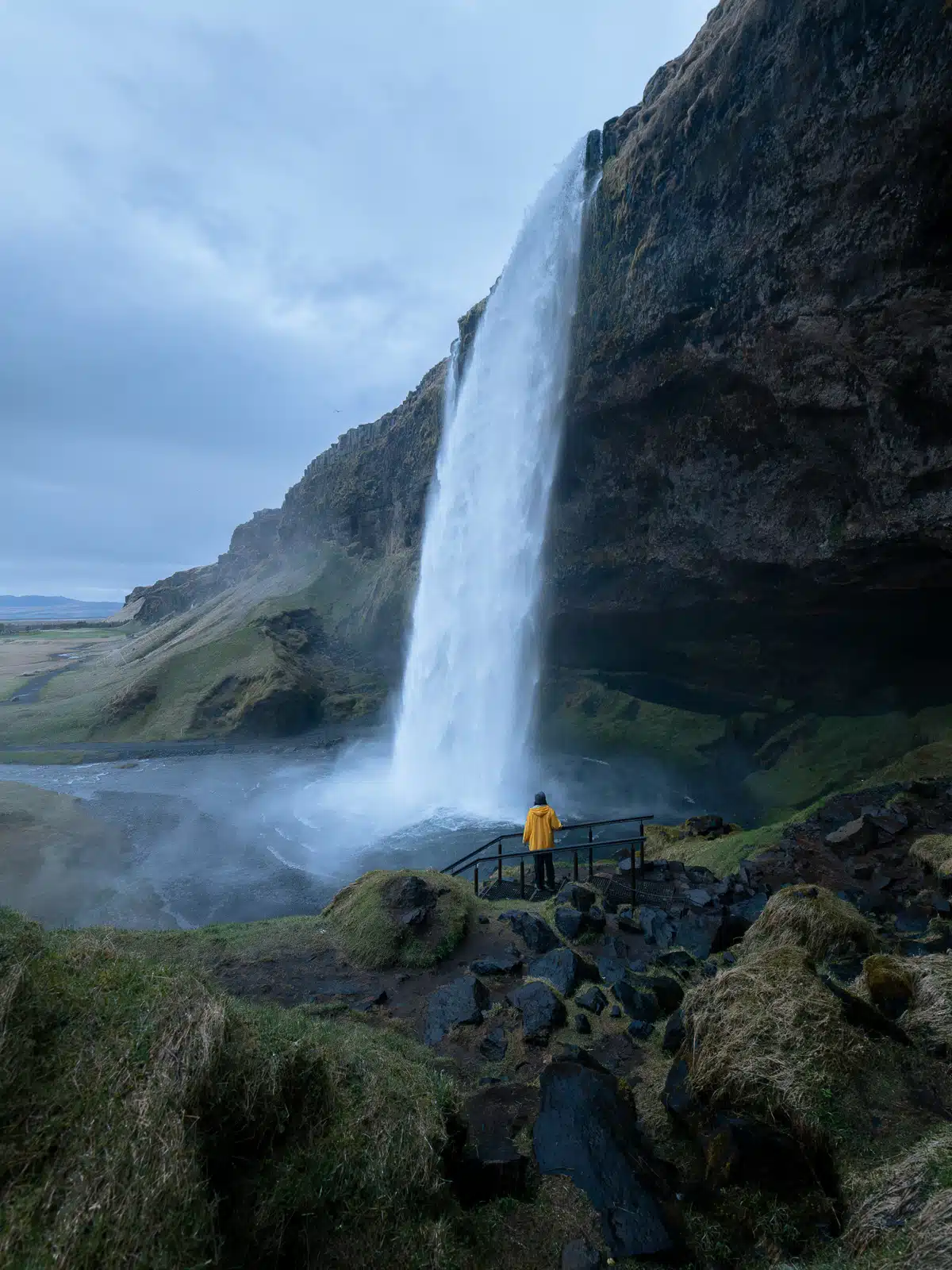 A woman alone looks at Seljalandsfoss in summer