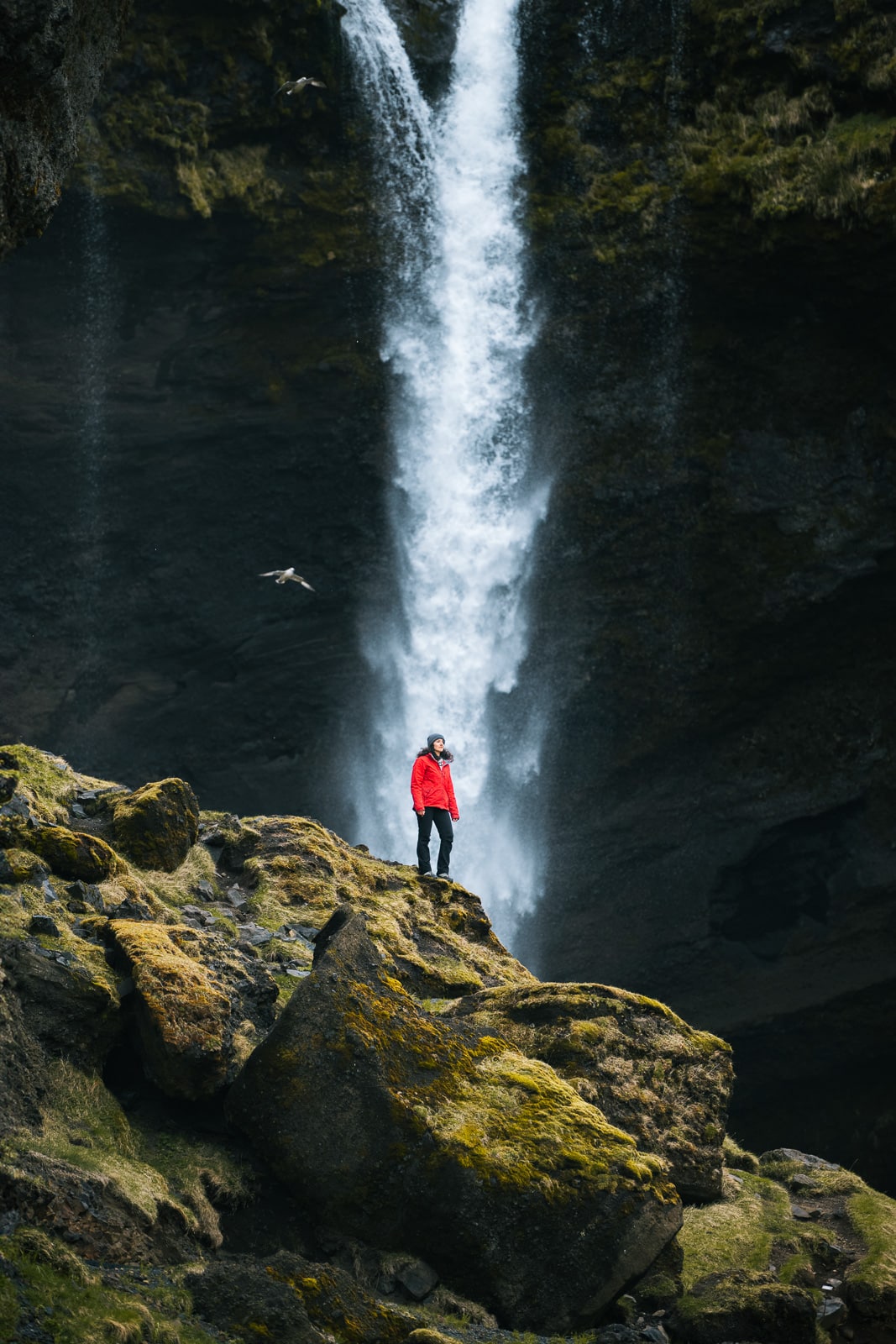 Une femme se tient devant Kvernufoss