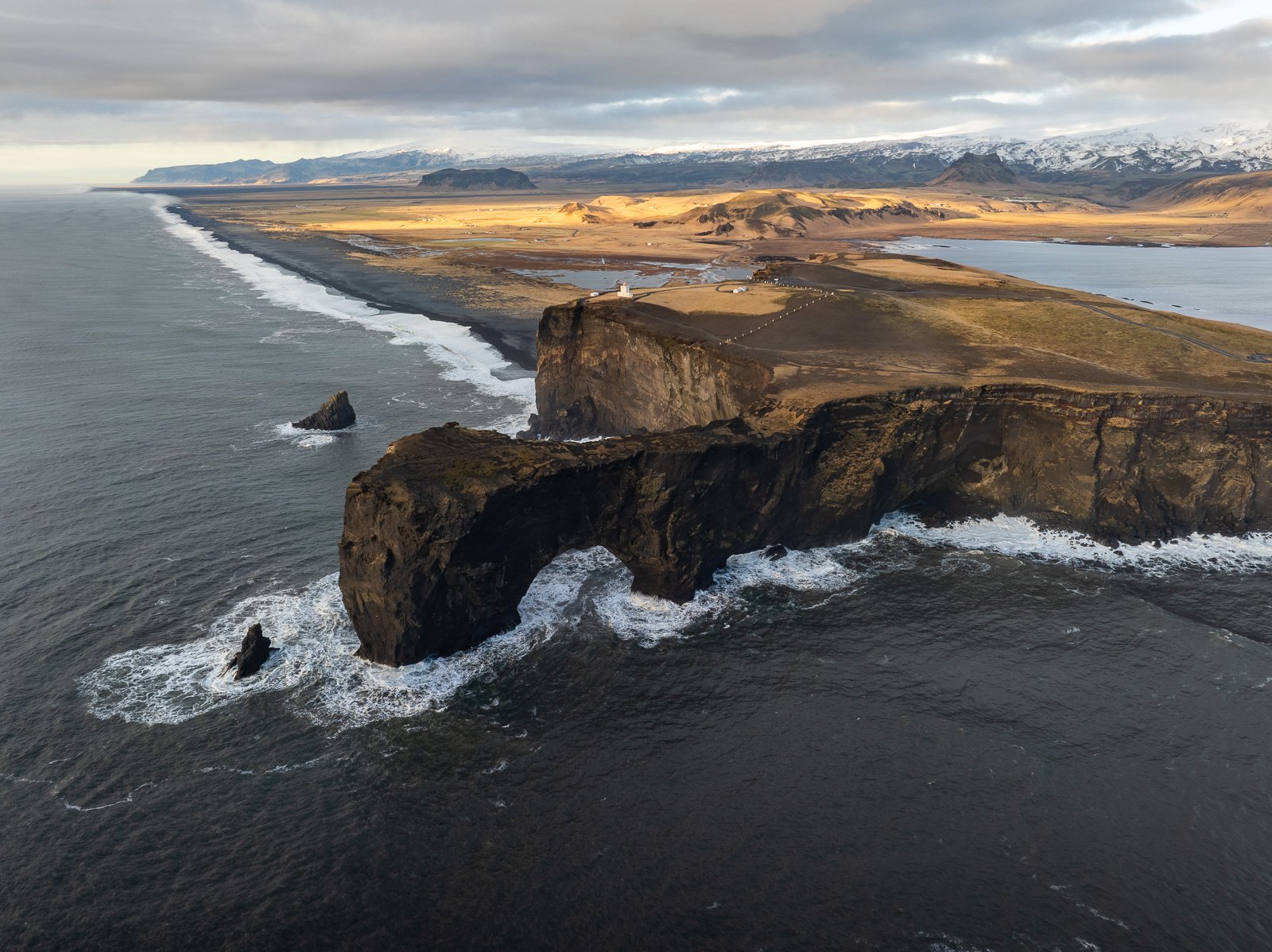 Vue aérienne des falaises de Dyrholaey en Islande au soleil couchant