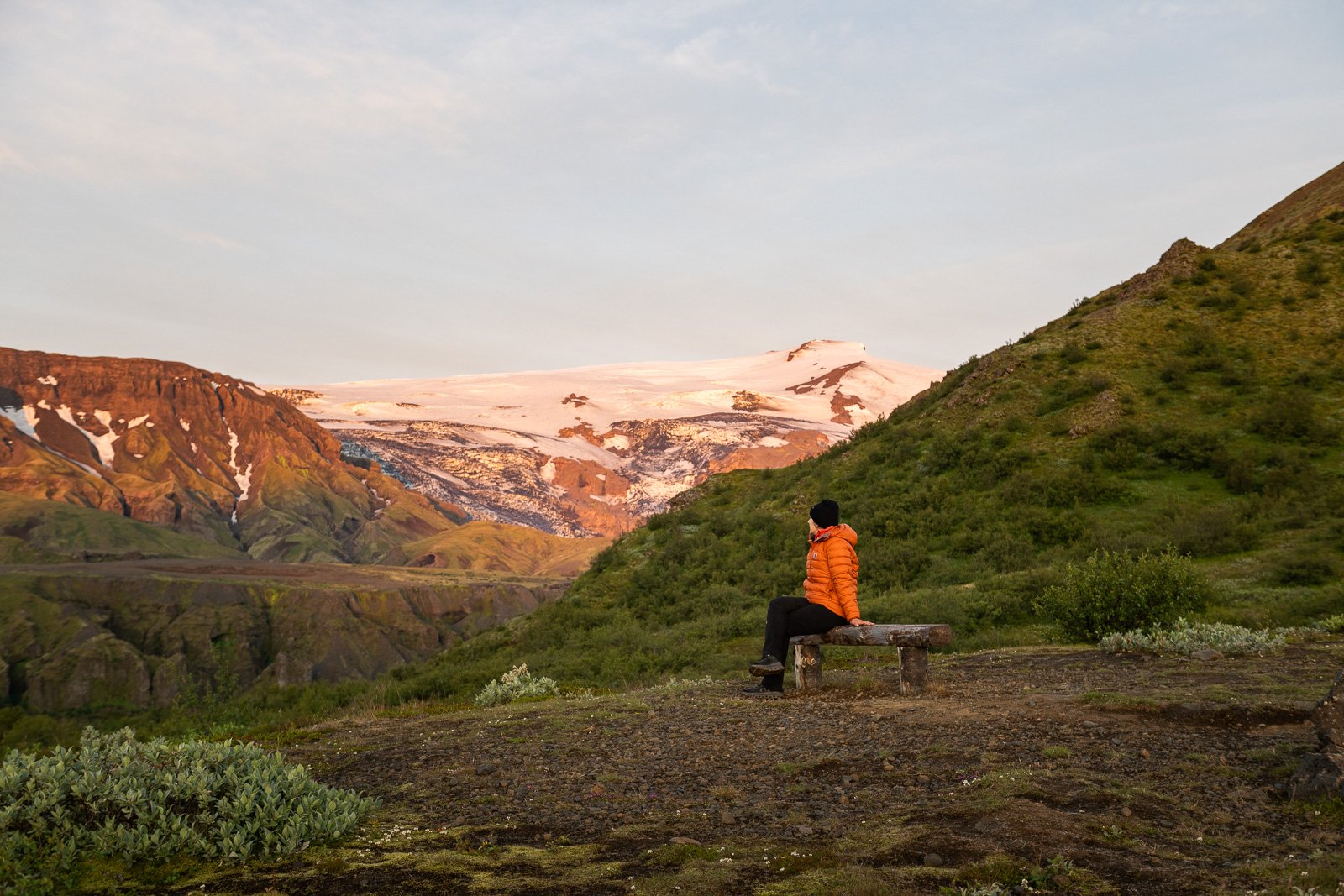 Femme qui regarde un glacier dans la vallée de Thorsmork au lever de soleil en Islande
