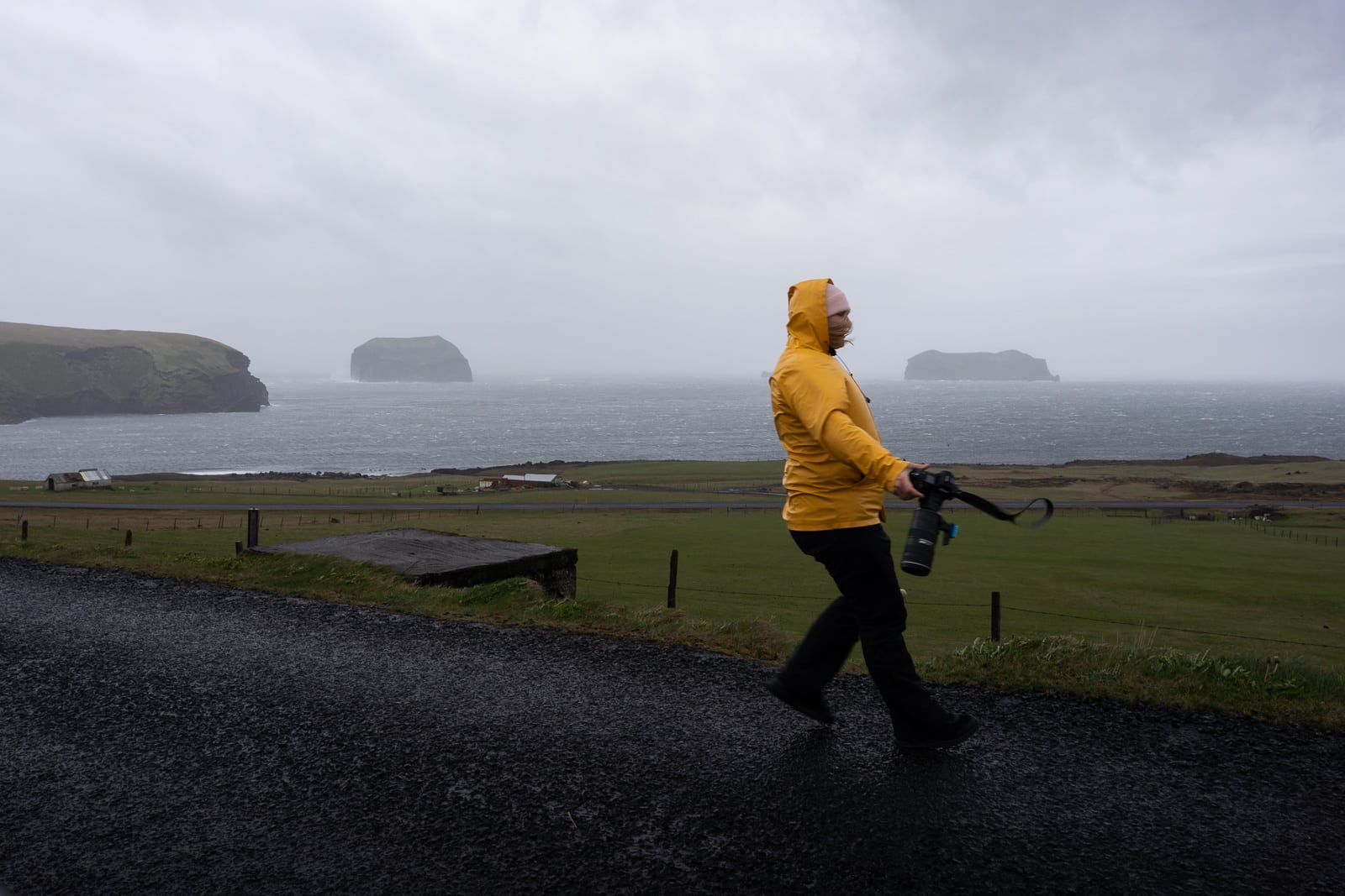 Une photographe tient à peine debout à cause d'une tempête aux Îles Vestmann en Islande