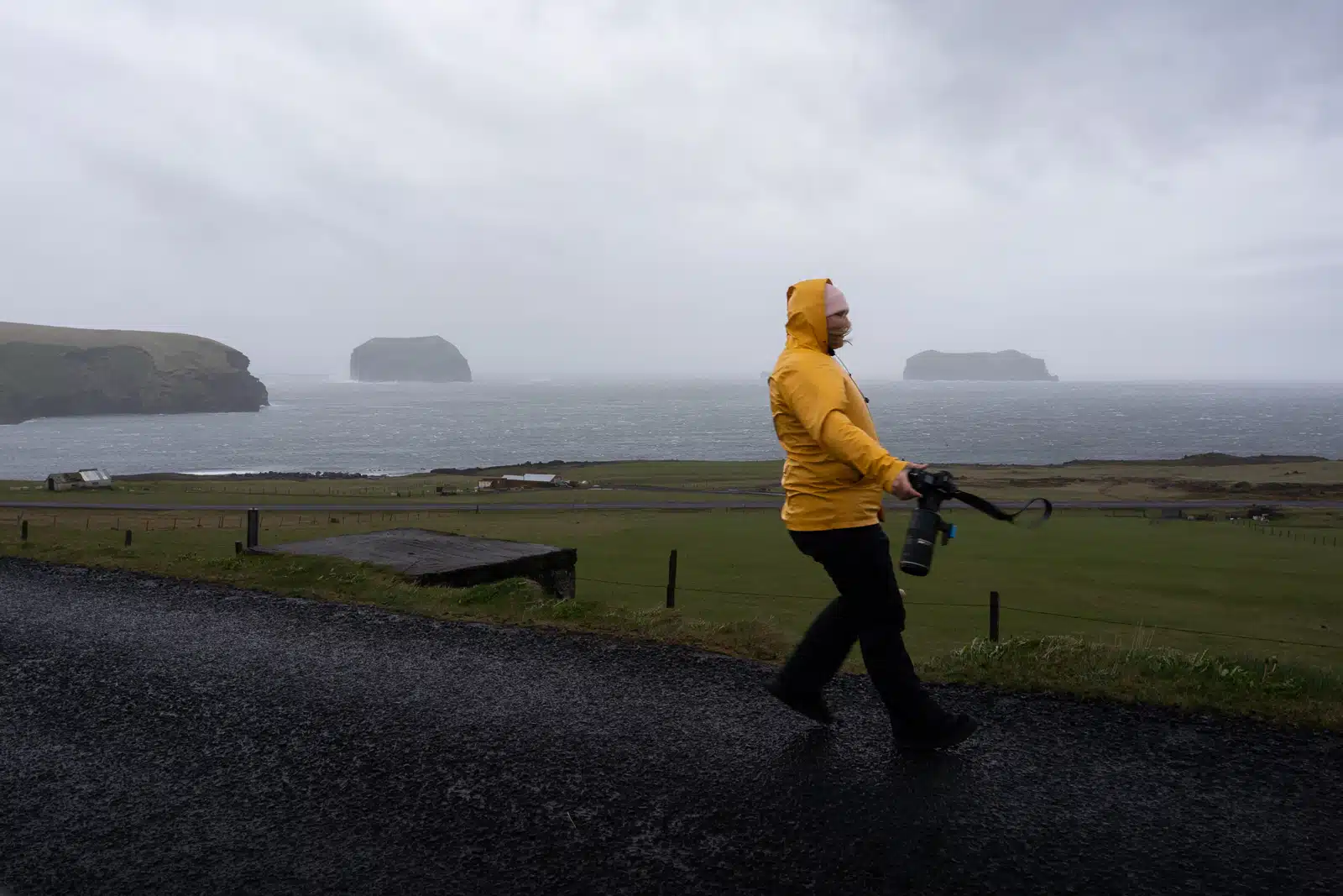 Une photographe tient à peine debout à cause d'une tempête aux Îles Vestmann en Islande