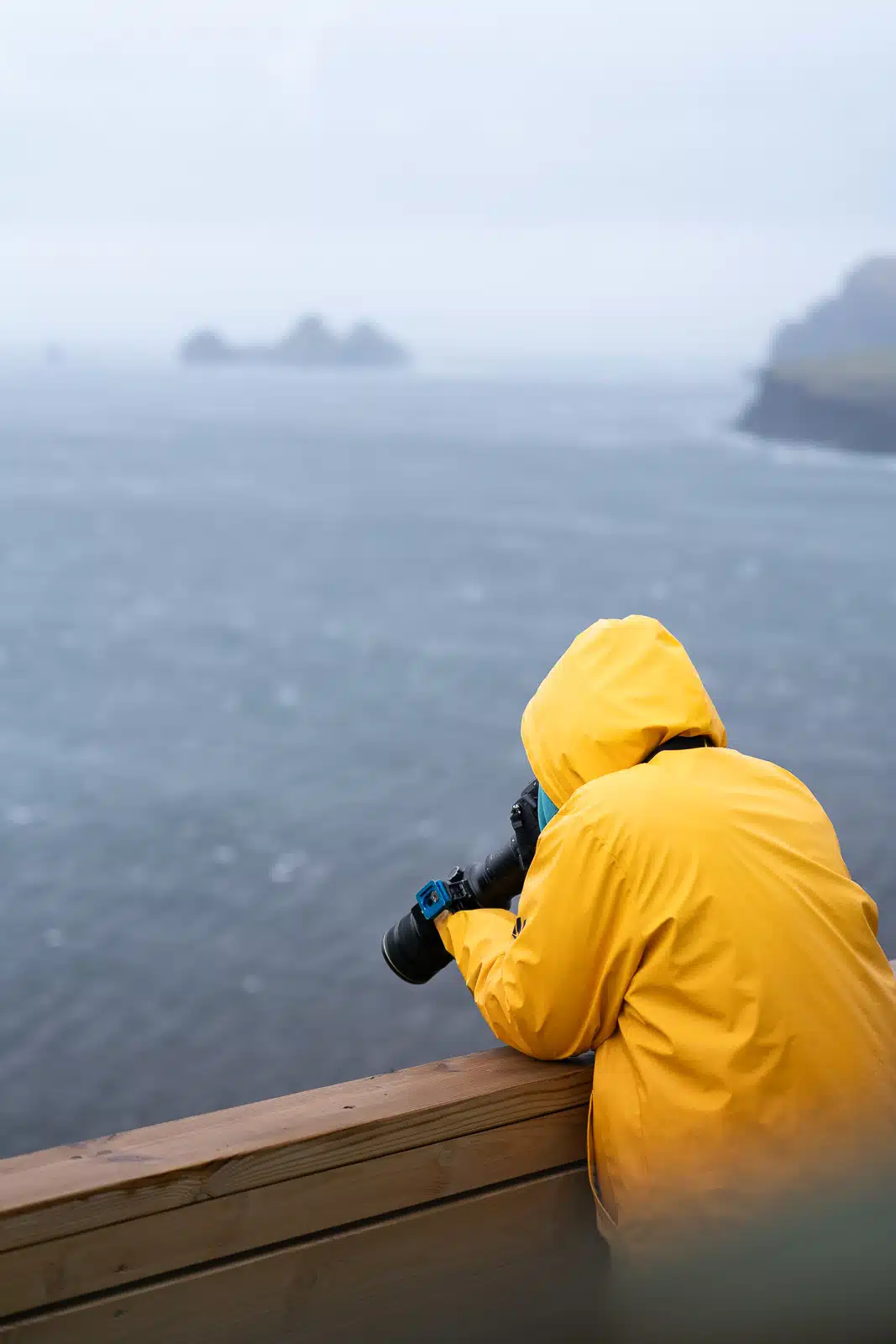 Photographe capturant les macareux depuis la plateforme d'observation des Îles Vestmann en Islande