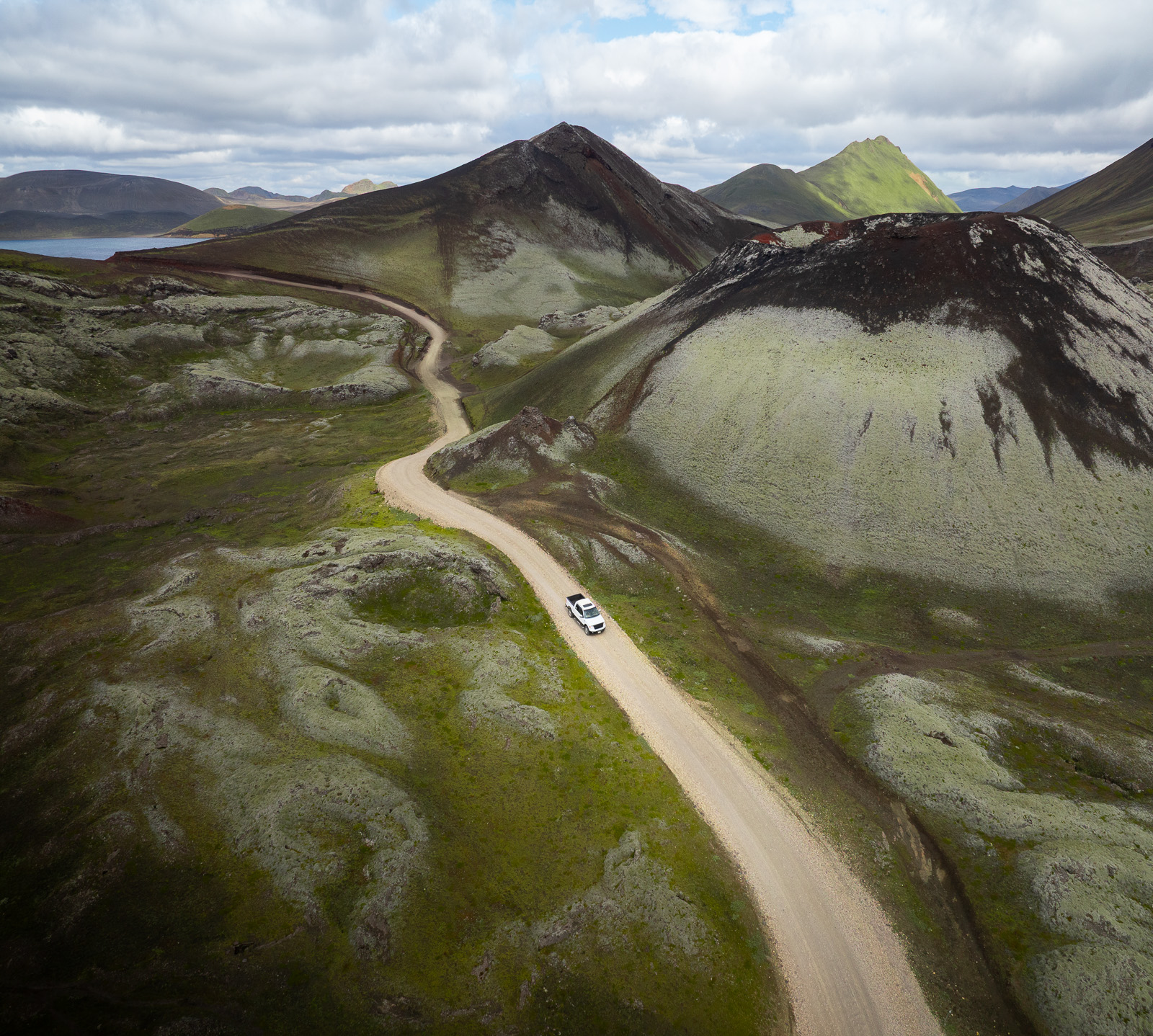 Vue aérienne d'une voiture qui roule entre deux cratères dans les Hautes-Terres en Islande