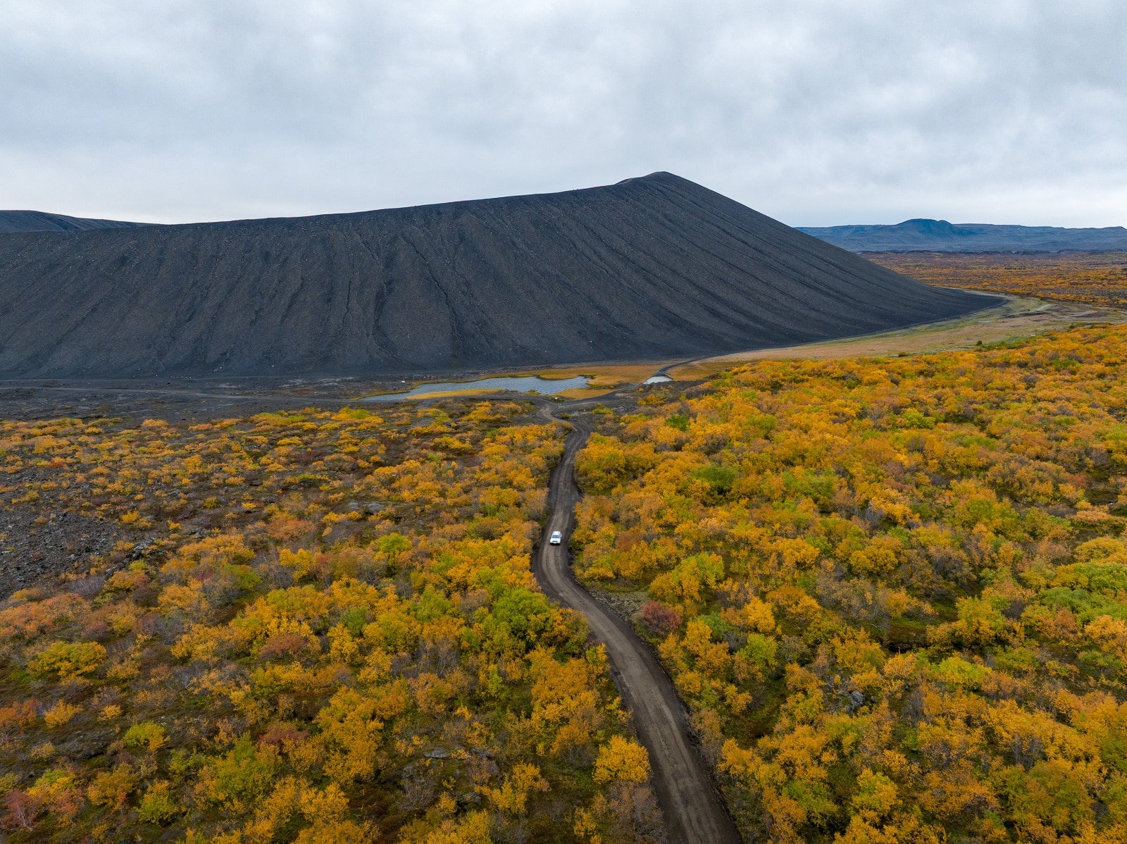 Photo en drone d'un volcan dans une foret avec les couleurs d'automne en Islande